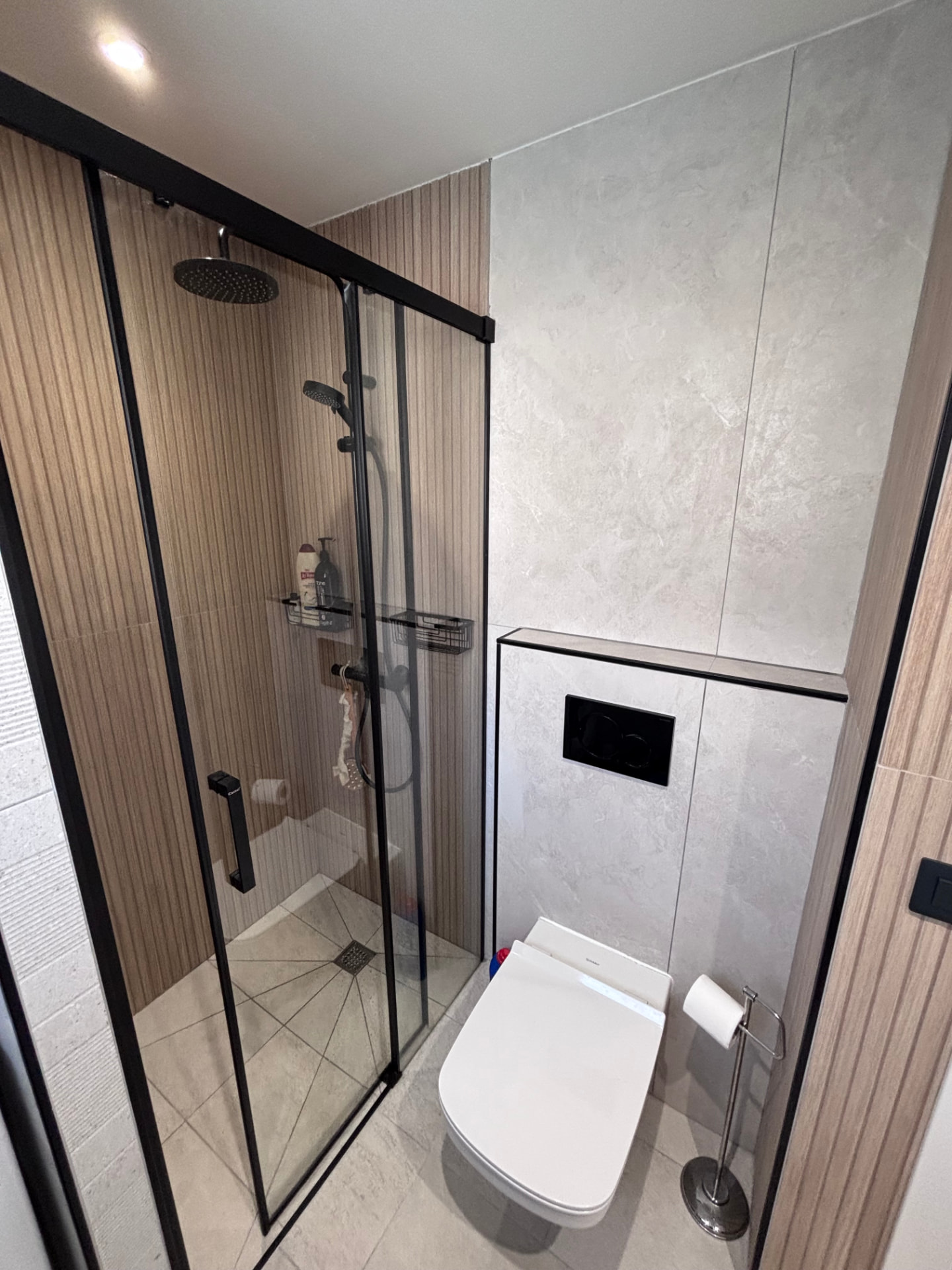 Dusch med regndusch och svart ramverk samt vägghängd wc i badrummet i Patalavaca