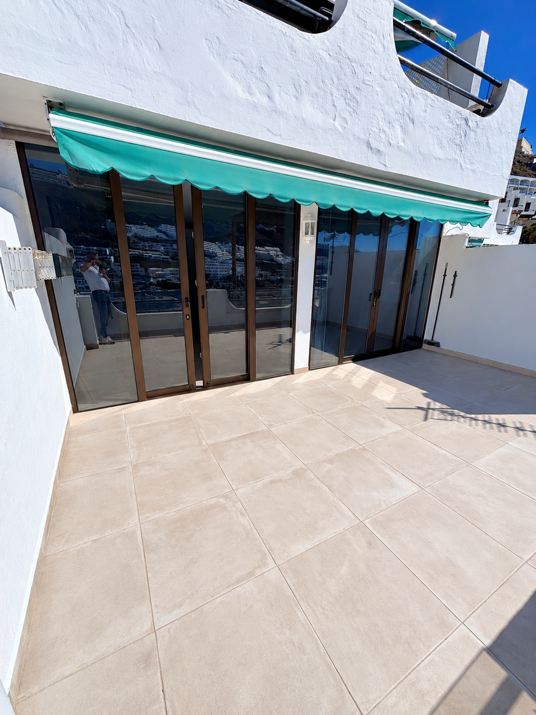 New sliding doors with dark frames facing the renovated terrace