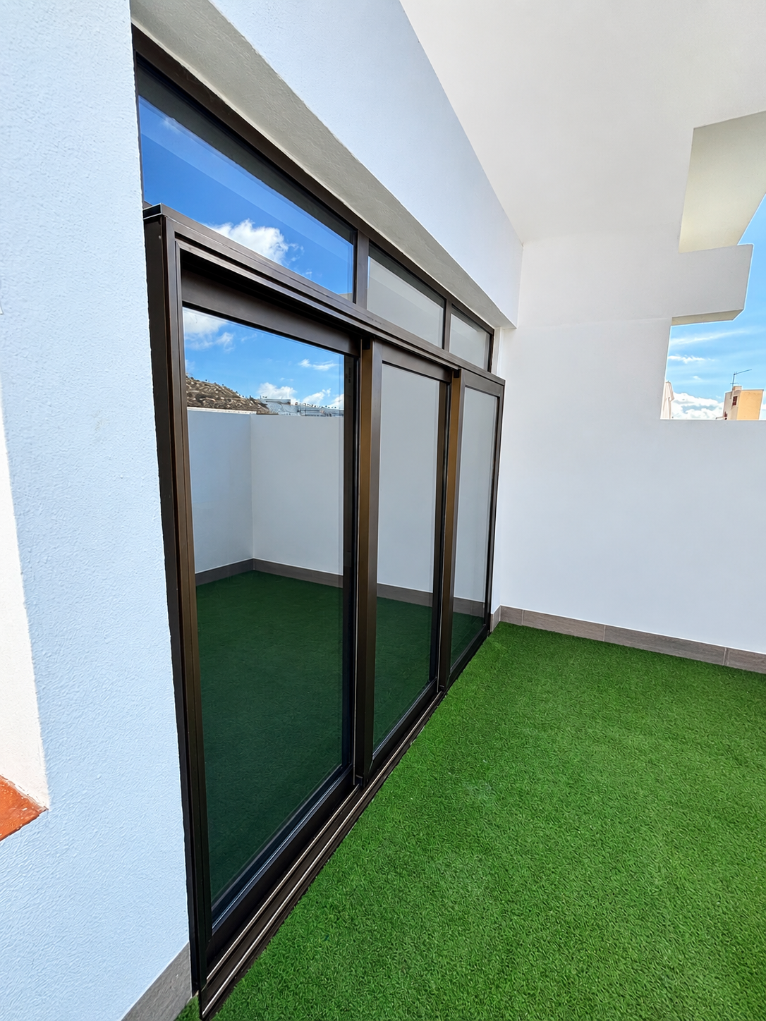 Nya skjutdörrar i brun aluminium sedda från terrassen